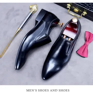 Flat lay of black leather men's business loafers with professional business accessories