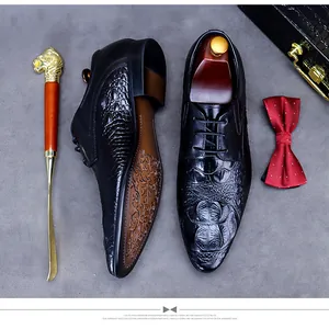 Vue à plat de chaussures derby noires en cuir embossé crocodile pour hommes avec accessoires