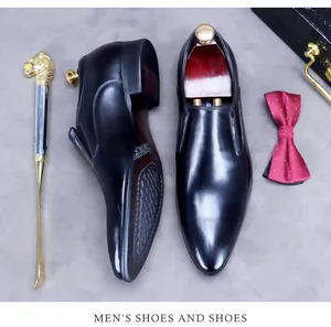 Top view of premium black leather business shoes with elegant pointed toe and accessories