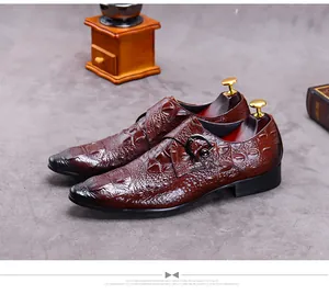 Detail of reddish-brown crocodile embossed monk strap leather shoe with buckle and dark toe
