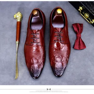 Vue à plat de chaussures derby en cuir bordeaux embossé crocodile avec accessoires pro