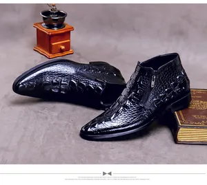 Primer plano de botas de hombre en cuero con textura de cocodrilo y cremallera lateral