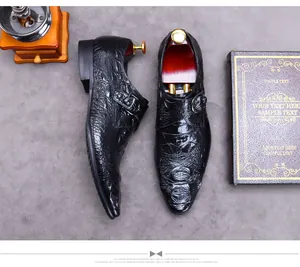 Overhead shot of black crocodile embossed leather monk strap shoes with wood shoe trees