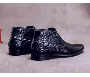Detalle de botas de cuero negro con textura de cocodrilo y cremallera lateral metálica
