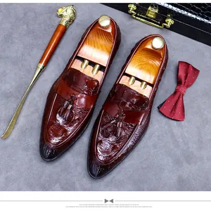 Detail of burgundy crocodile-embossed leather loafers with tassels and wooden shoe trees