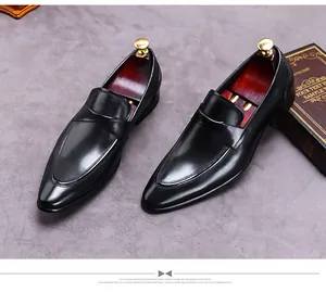 Top view of premium black leather dress shoes with wooden shoe trees on a grey background
