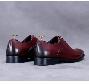 Makroansicht polierter burgunderroter Rindslederschuhe mit Vintage Farbverlaufseffekt