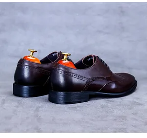 Détail de chaussures Richelieu marron foncé en cuir poli avec perforations Brogue classiques