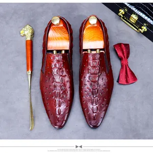 Detail of reddish-brown crocodile embossed leather shoes with premium lion-head shoehorn