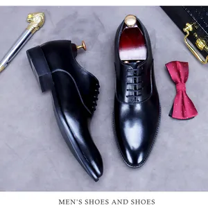 Draufsicht auf schwarze Leder-Business-Schuhe mit Schuhspannern aus Holz auf grauem Grund