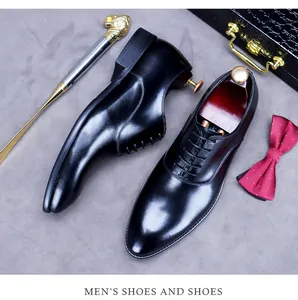 Nahaufnahme schwarzer Oxford-Schuhe aus Leder mit roten Schuhspannern und Schuhlöffel