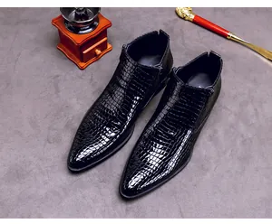 Detail der schwarzen Krokodil-Prägung auf Herren-Stiefeletten aus Lackleder mit Spitze