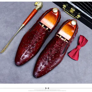 Detail of luxury burgundy loafers with crocodile texture next to elegant accessories