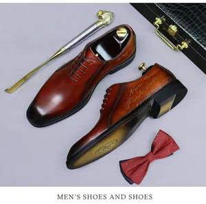 Detalle de zapato oxford de cuero degradado con grabado láser y calzador de cabeza de león