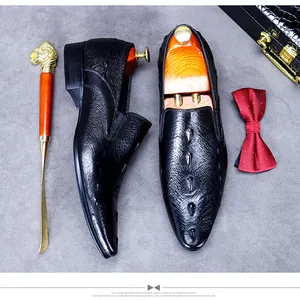 Detailansicht von schwarzen Business-Schuhen aus Leder mit Krokoprägung und Herren-Accessoires