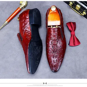 Detail of luxury burgundy loafers with ostrich and crocodile embossed leather texture