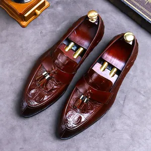 Brown crocodile embossed leather loafers for men with decorative tassels in a vintage style