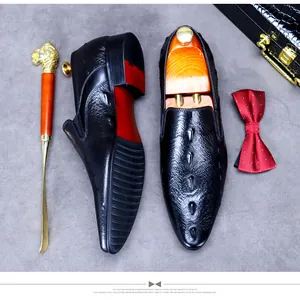 Detailansicht schwarzer Leder-Loafer mit Krokodilmuster und klassischen Schuh-Accessoires