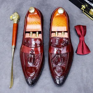 Burgundy crocodile embossed leather loafers for men with decorative tassels and wood shoe tree