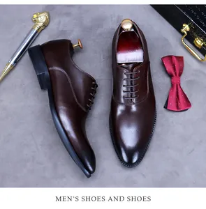 Detail von dunkelbraunen Leder-Oxfords mit Herren-Accessoires auf strukturiertem Grund