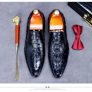 Flat lay of men's leather business shoes with crocodile pattern and classic dress accessories
