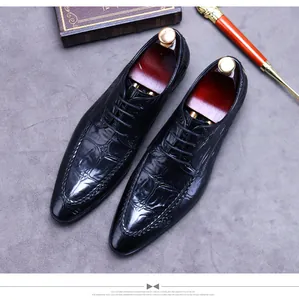 Macro detail of black embossed crocodile texture and stitching on men's oxford shoes