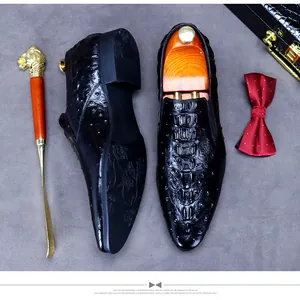 Detail of black crocodile embossed leather loafers with intricate engraved soles