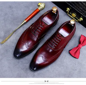 Détails macro des perforations richelieu et du cuir bordeaux sur chaussures habillées