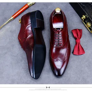 Vue de dessus de chaussures brogue en cuir bordeaux avec accessoires sur tissu gris