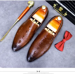 Makroaufnahme brauner strukturierter Leder-Loafer mit Schuhspannern aus Holz und Gold-Zubehör