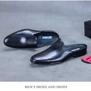 Close-up of black genuine leather business mules with detailed side script engraving