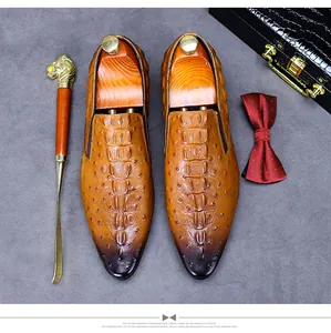 Detail of luxury brown leather shoes with crocodile and ostrich pattern and formal accessories