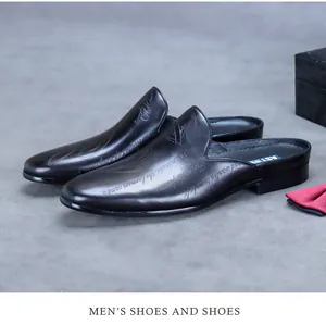 Detail of black leather business mules featuring laser-engraved artistic script patterns