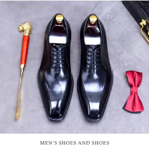 Close-up of polished black leather derby shoes with elegant business accessories