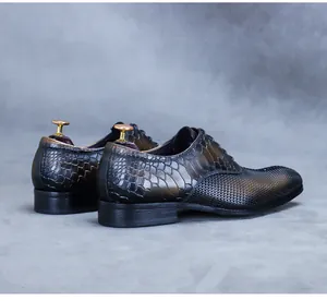 Detail view of premium black dress shoes with crocodile texture and woven leather details