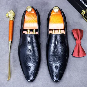 Schwarze Herren-Business-Lederschuhe mit Kroko-Struktur auf grauem Hintergrund