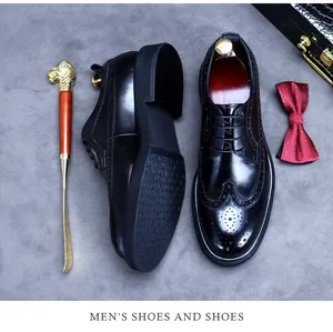 Dettaglio di scarpe brogue in pelle nera con motivo wingtip e suola antiscivolo