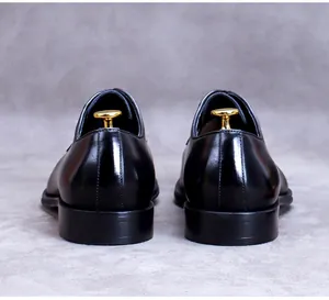 Detailed rear view of polished black leather business shoes with elegant gold shoe trees