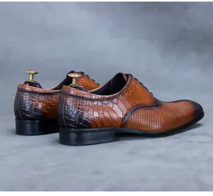 Detail of brown leather oxford shoes featuring premium crocodile embossed texture