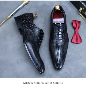 Flat lay of black leather dress shoes with crocodile texture and woven patterns