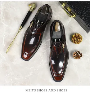 Detail of burgundy patent leather monk strap shoe with gold buckle and square toe