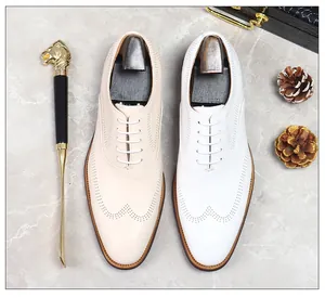 Detailed view of men's wingtip brogue leather shoes in white and beige with shoe trees