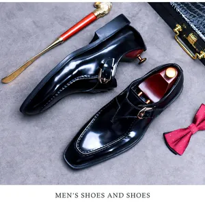 Detail of black patent leather monk strap shoe with gold buckle and luxury accessories