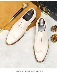 Detailed top view of cream leather brogue shoes with elegant wingtip patterns and laces