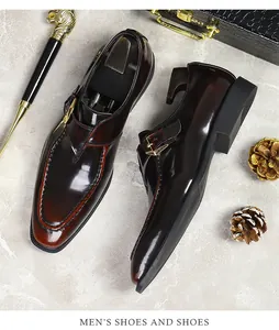 Detail of dark brown burnished leather monk strap shoe with gold buckle on marble