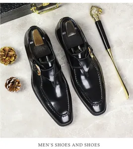 Close-up of black patent leather monk strap shoes with golden buckle and u-tip stitching