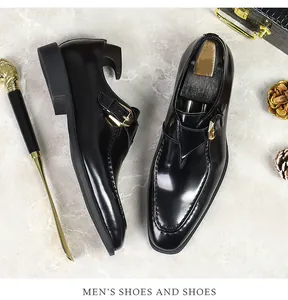 Detailed top view of black patent leather monk strap shoes with metallic buckle detail