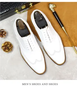 Macro shot of white leather wingtip brogue shoes with elegant perforation and laces