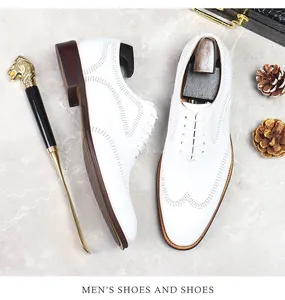 Detail of white leather brogue shoes with decorative perforations and lace-up design