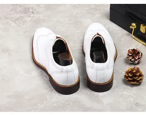Detail of white leather brogue shoes showing intricate perforated wingtip carvings